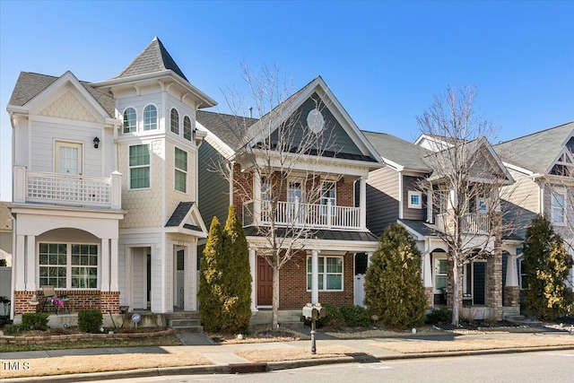 view of front of home with brick siding and a balcony