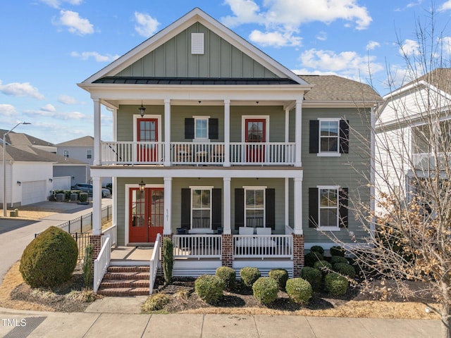 view of front of house with covered porch, french doors, board and batten siding, and a balcony