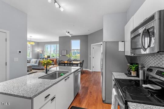 kitchen featuring stainless steel appliances, dark wood-style flooring, a sink, and white cabinets