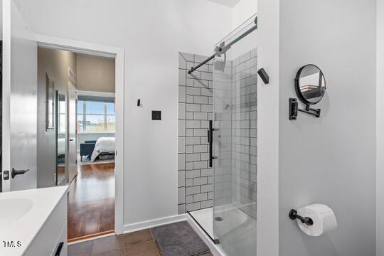 full bathroom featuring a stall shower, vanity, baseboards, and tile patterned floors