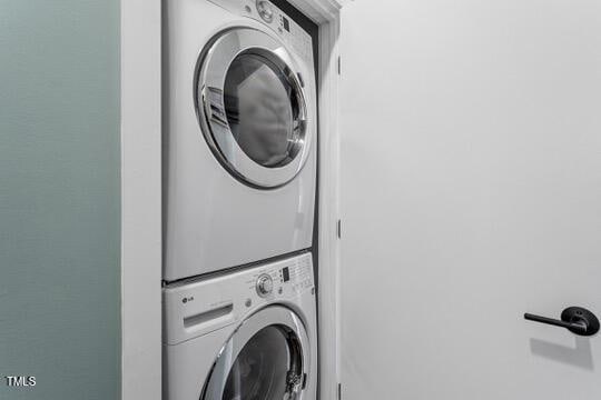 washroom featuring stacked washer and dryer and laundry area