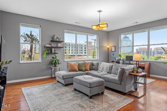 living room with a view of city, wood finished floors, and baseboards