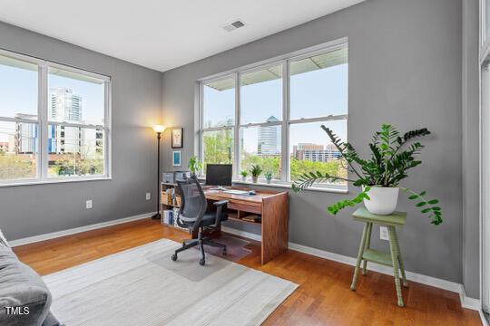 office space with visible vents, baseboards, and wood finished floors