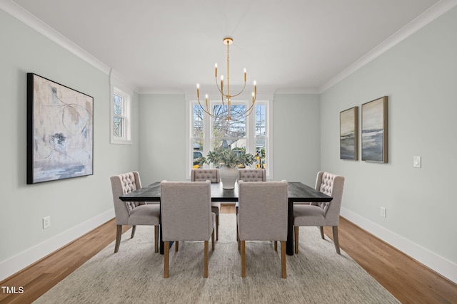 dining space with baseboards, an inviting chandelier, wood finished floors, and crown molding