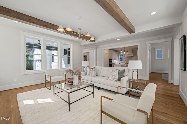 living area featuring wood finished floors, baseboards, beam ceiling, recessed lighting, and a notable chandelier