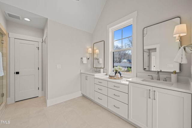 full bath with visible vents, a sink, a shower stall, double vanity, and lofted ceiling