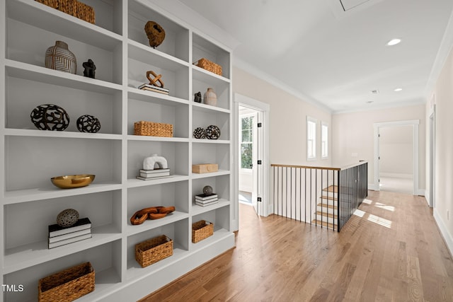 hallway with baseboards, ornamental molding, an upstairs landing, recessed lighting, and light wood-style floors