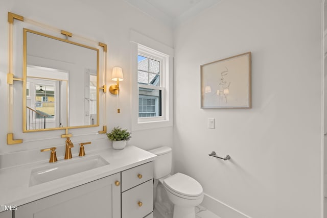 bathroom featuring vanity, toilet, and baseboards