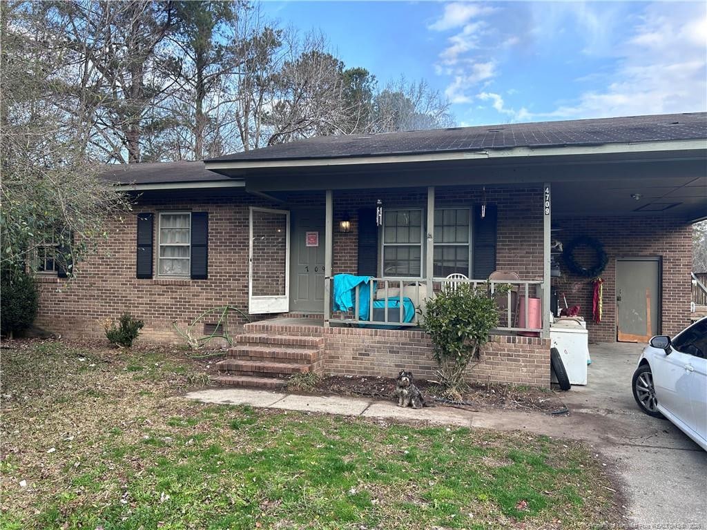 view of front of property with a carport, brick siding, and a porch