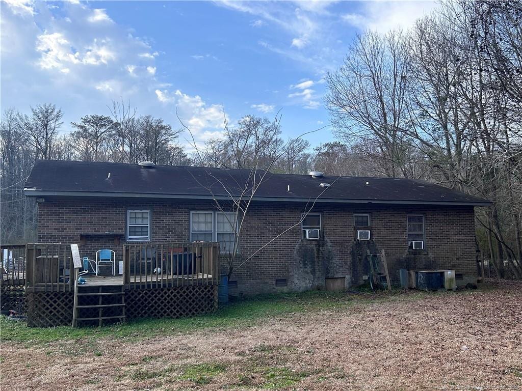 back of property featuring cooling unit, crawl space, brick siding, and a wooden deck