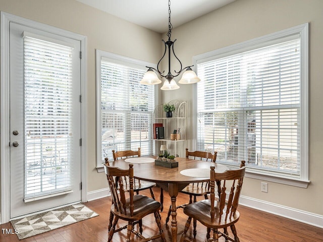 dining room featuring an inviting chandelier, baseboards, and wood finished floors