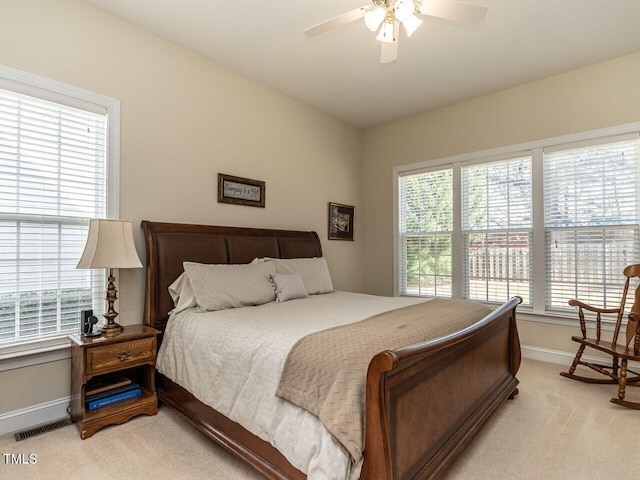 bedroom featuring light carpet, baseboards, multiple windows, and visible vents