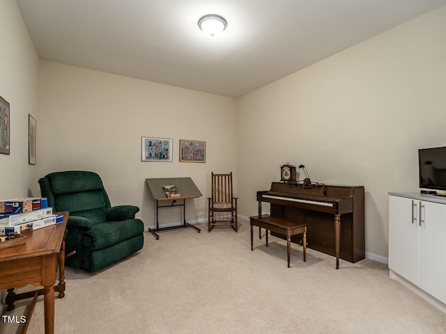 living area featuring light carpet and baseboards