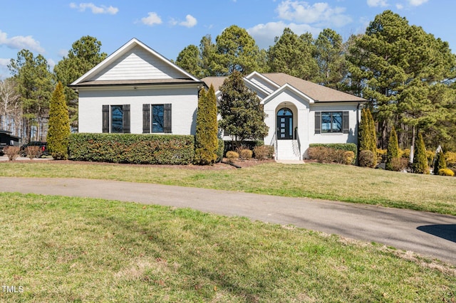 single story home featuring a front yard and brick siding