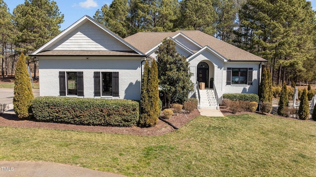 view of front facade with brick siding and a front yard