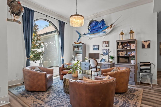 living area featuring baseboards, crown molding, an inviting chandelier, and wood finished floors