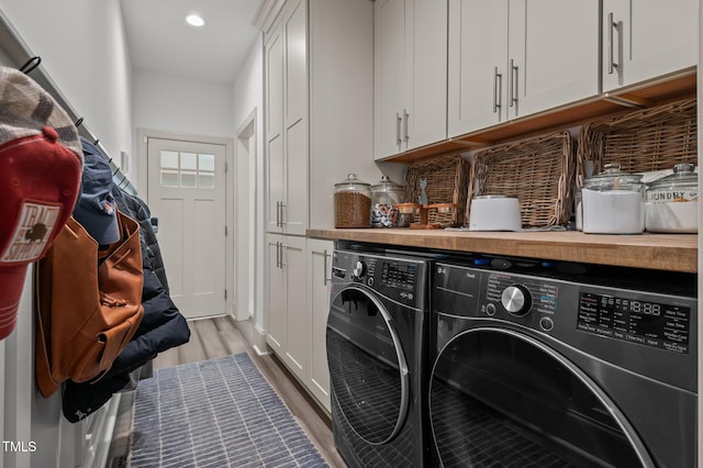 washroom featuring light wood-type flooring, cabinet space, recessed lighting, and independent washer and dryer