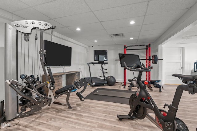 workout area featuring a drop ceiling, wood finished floors, and visible vents