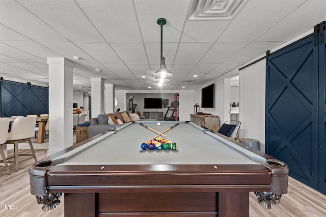 playroom with light wood-style floors, recessed lighting, a drop ceiling, and a barn door