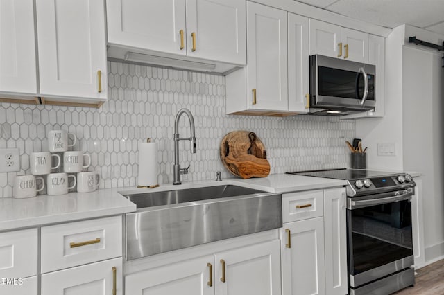 kitchen featuring white cabinetry, appliances with stainless steel finishes, light countertops, and a sink