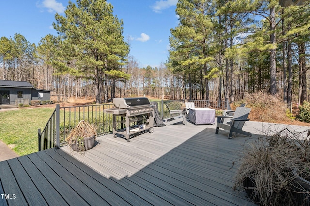 wooden deck featuring a yard and a grill