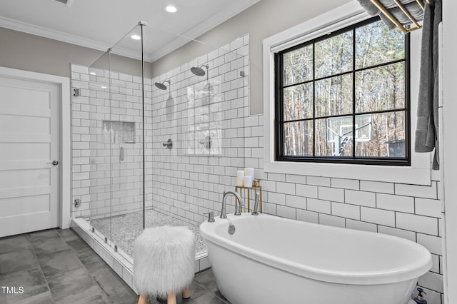 bathroom featuring ornamental molding, a freestanding bath, a shower stall, tile walls, and recessed lighting