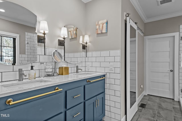 bathroom with crown molding, visible vents, a sink, and tile walls