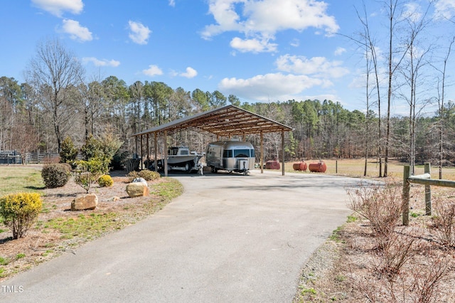 exterior space with aphalt driveway and a wooded view