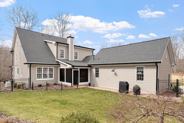 back of property featuring a shingled roof, a lawn, a sunroom, a chimney, and fence