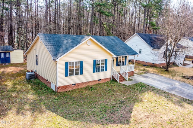 view of front of property with crawl space, roof with shingles, a porch, and an outdoor structure