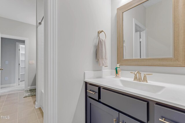 full bath with tile patterned flooring, vanity, and baseboards