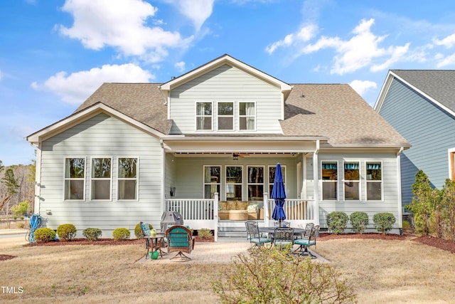 view of front of home with ceiling fan, a shingled roof, and a porch