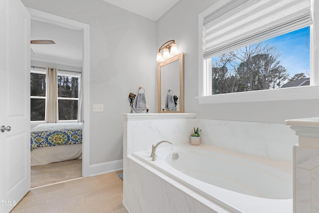 bathroom with a garden tub, baseboards, and ensuite bathroom