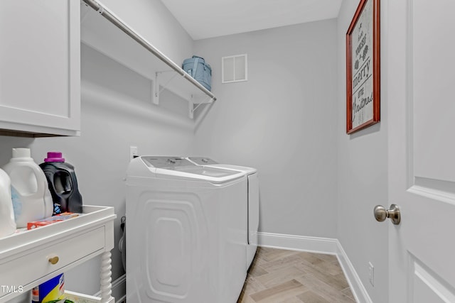 laundry area featuring cabinet space, baseboards, visible vents, and washer and clothes dryer