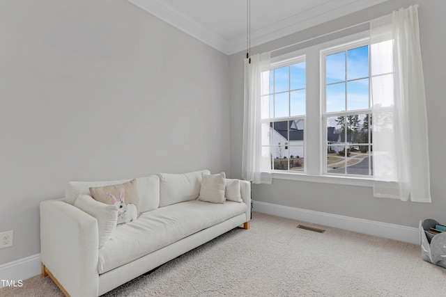 living area with baseboards, carpet floors, visible vents, and crown molding