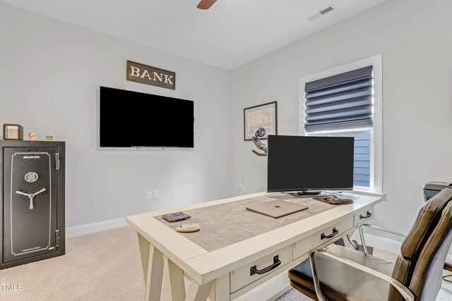 office area with visible vents, baseboards, a ceiling fan, and light colored carpet