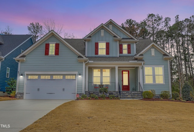 view of front of home with driveway, a porch, an attached garage, a front lawn, and board and batten siding