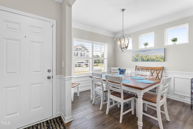 dining room featuring a wainscoted wall, crown molding, dark wood finished floors, a decorative wall, and a chandelier