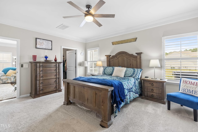 carpeted bedroom featuring crown molding, visible vents, a spacious closet, ceiling fan, and baseboards