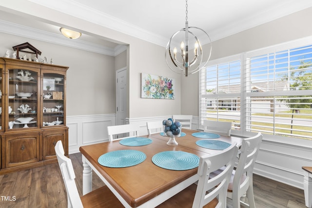 dining space featuring a chandelier, a wainscoted wall, wood finished floors, and crown molding