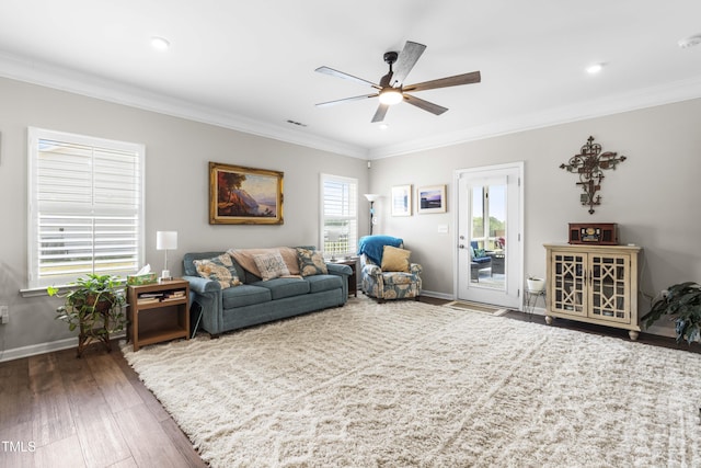 living area featuring baseboards, ceiling fan, wood finished floors, and crown molding