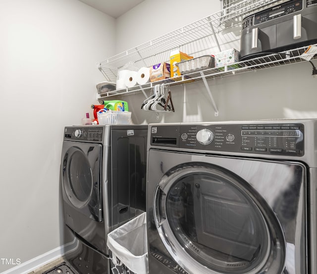 laundry room featuring laundry area, baseboards, and separate washer and dryer