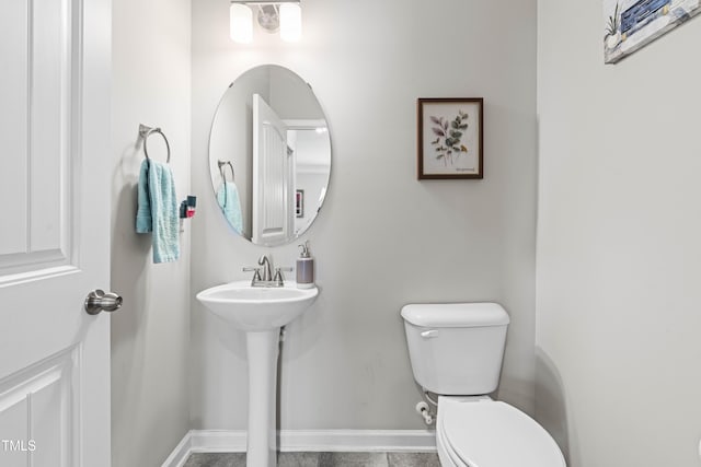 bathroom featuring toilet and baseboards