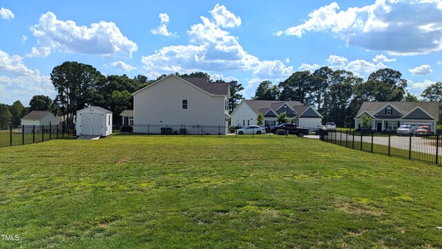 view of yard with a fenced backyard, a residential view, a storage unit, and an outdoor structure