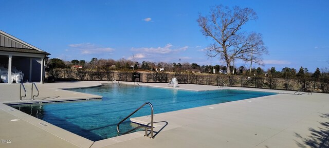 pool with a patio and fence