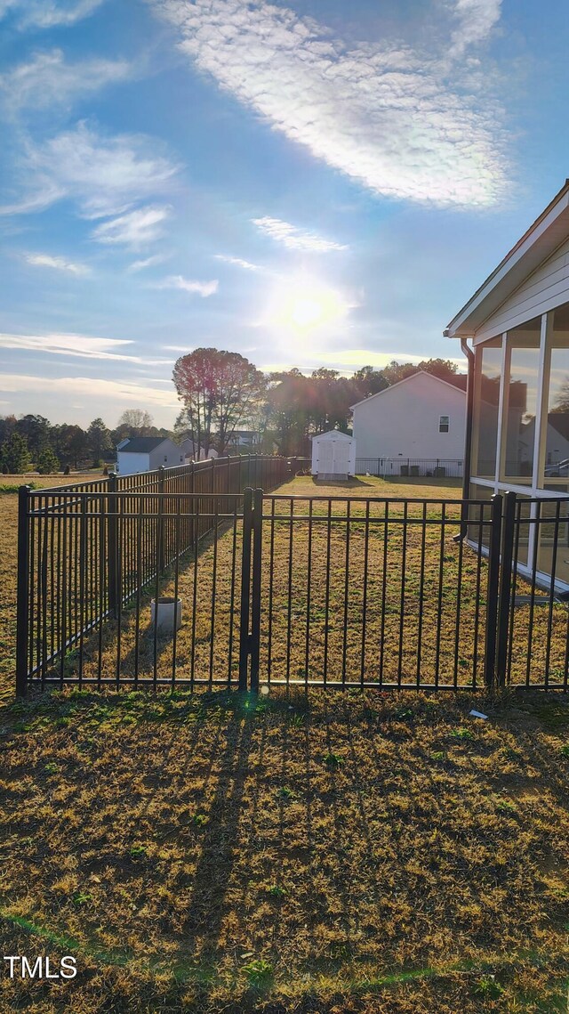 view of yard featuring a sunroom and a fenced backyard