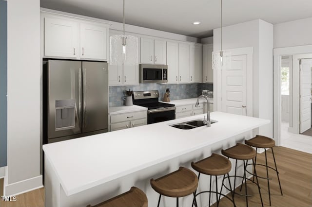 504 Yeowell Dr, Chapel Hill, NC 27514 - kitchen featuring stainless steel appliances, light wood-style flooring, backsplash, white cabinetry, and a kitchen breakfast bar