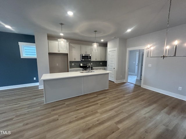 504 Yeowell Dr, Chapel Hill, NC 27514 - kitchen featuring appliances with stainless steel finishes, light countertops, white cabinetry, a center island with sink, and recessed lighting