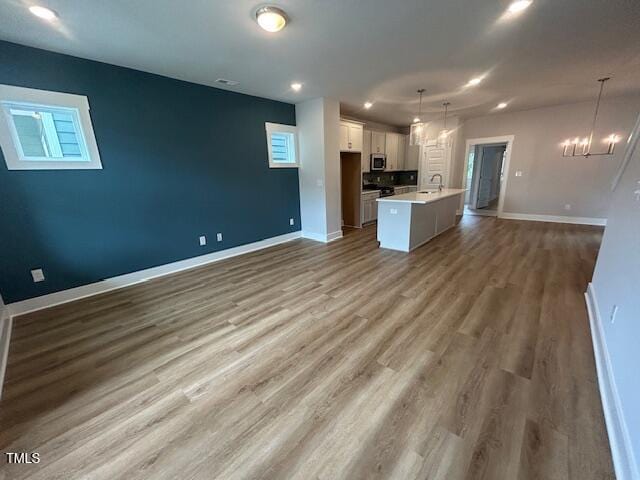 504 Yeowell Dr, Chapel Hill, NC 27514 - kitchen featuring a chandelier, open floor plan, white cabinetry, stainless steel microwave, and light countertops