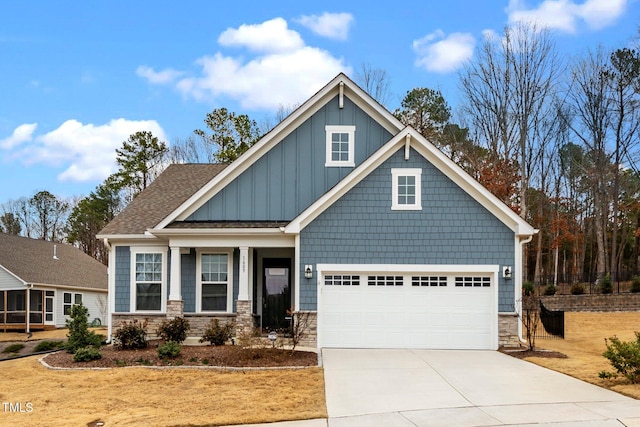 craftsman house with roof with shingles, concrete driveway, an attached garage, board and batten siding, and stone siding